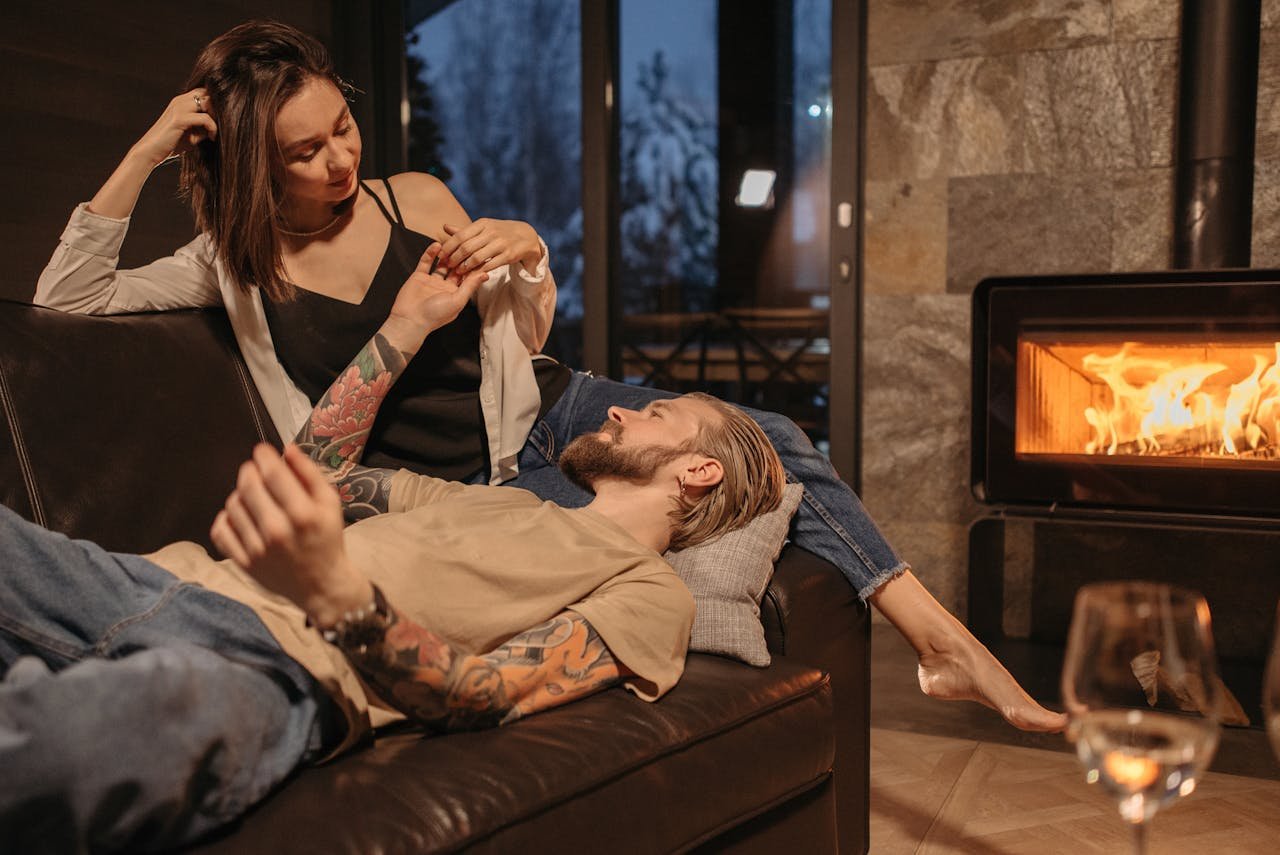 A couple enjoying a winter evening by the fireplace, creating a warm and intimate atmosphere.